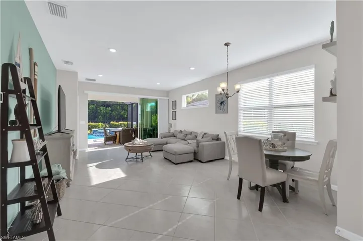 Dining space with a chandelier, light tile patterned flooring, and recessed lighting