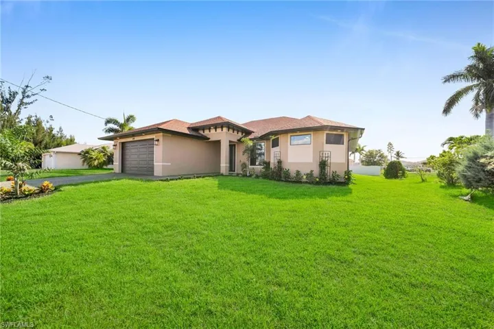 View of front of house with a front yard and a garage