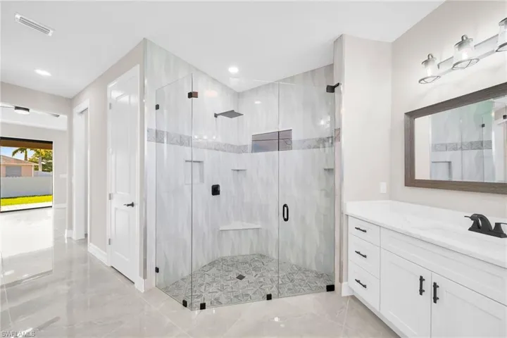 Bathroom featuring tile flooring, an enclosed shower, and vanity