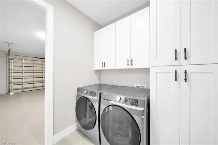 Laundry area featuring cabinets, washing machine and dryer, and washer hookup
