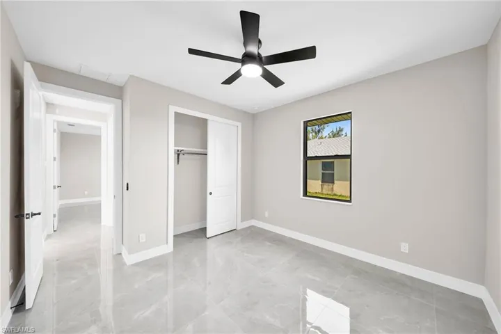 Unfurnished bedroom with a closet, ceiling fan, and light tile flooring