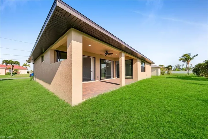 Back of house with a yard, ceiling fan, and a patio
