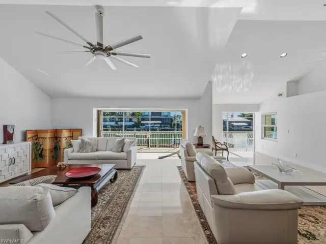 Living area featuring plenty of natural light, light tile patterned flooring, a ceiling fan, and high vaulted ceiling