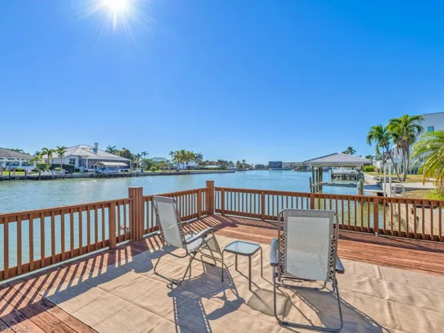Dock featuring boat lift and a deck with water view