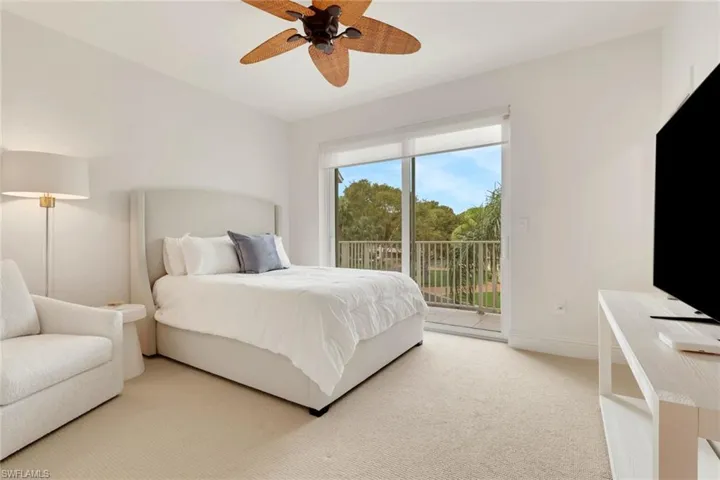 Bedroom with light carpet, access to exterior, and a ceiling fan