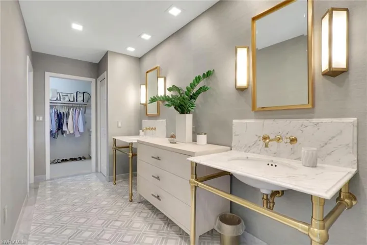 Full bath with a walk in closet and baseboards
