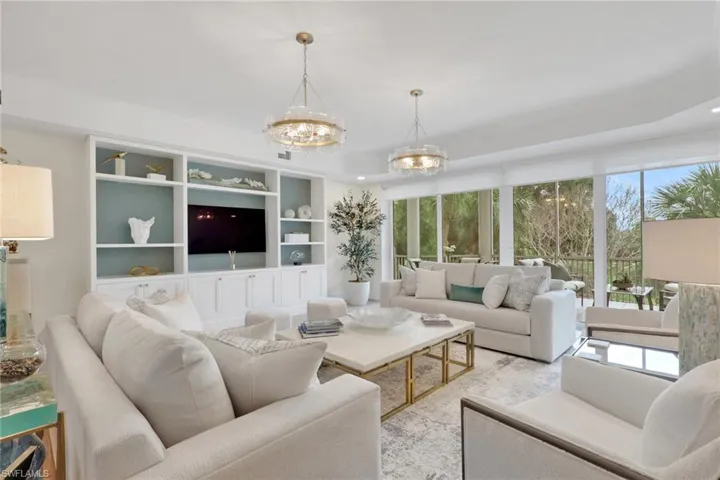 Living area featuring built in shelves and suspended lighting