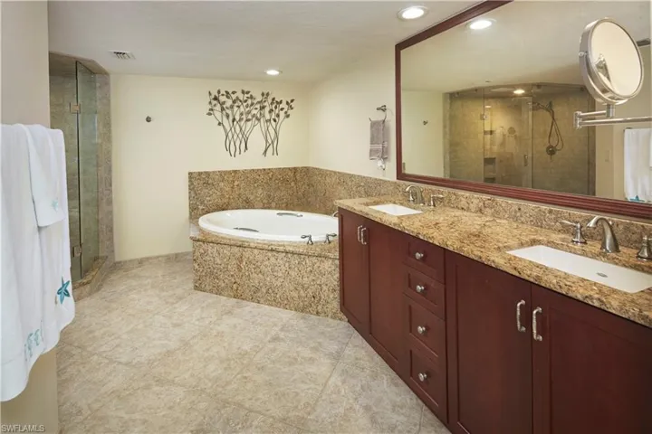 Primary en suite bathroom with dual sinks, walk in shower and soaking tub.