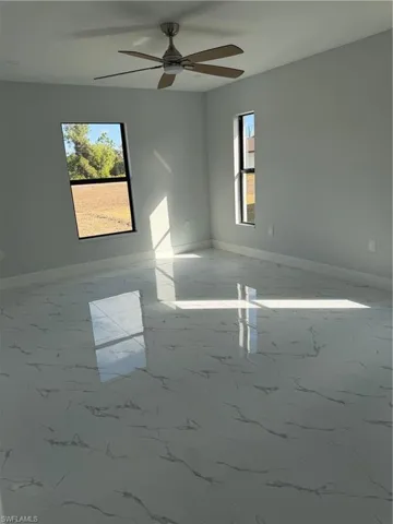 Spare room featuring light marble finish flooring and ceiling fan