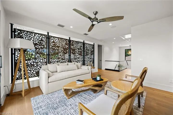 Living area with a ceiling fan, light wood-style floors, and recessed lighting