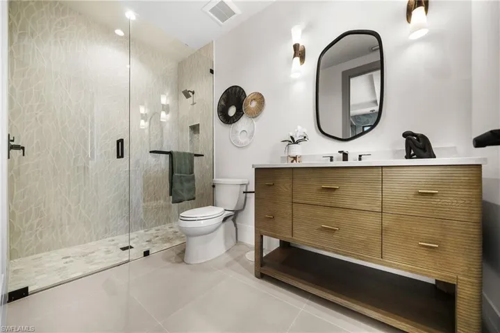 Full bath with vanity, a shower stall, and tile patterned flooring