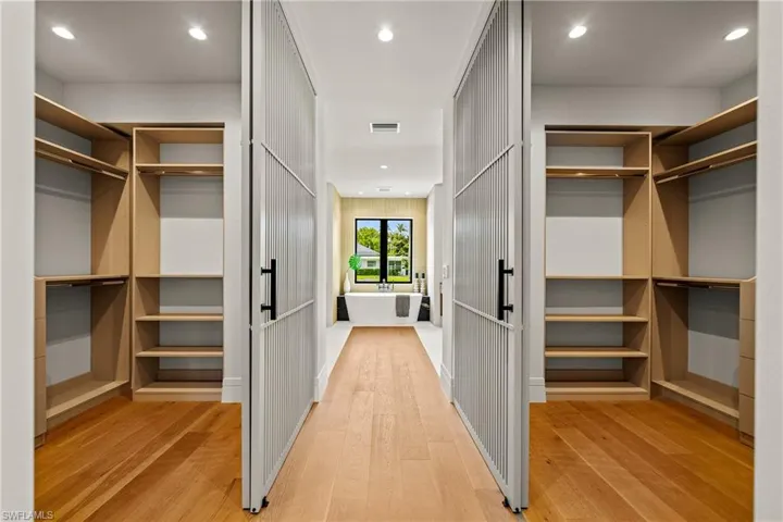 Walk in closet with light wood-style floors