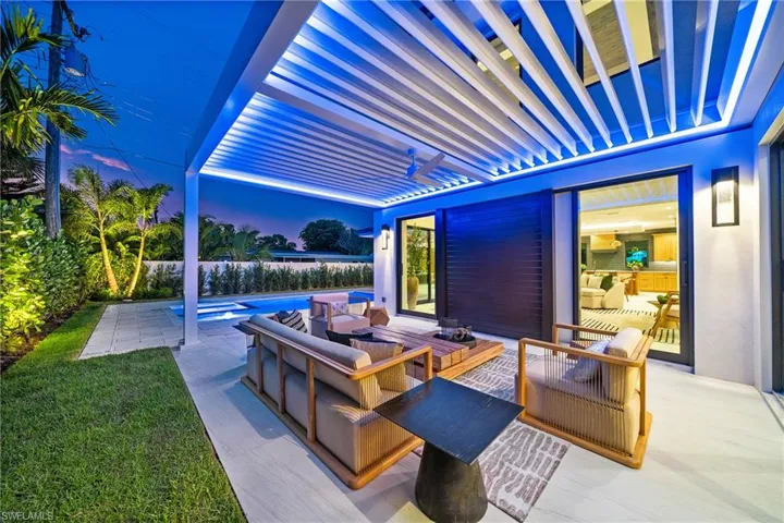 Fenced backyard featuring an outdoor hangout area, a patio area, and a pool with connected hot tub