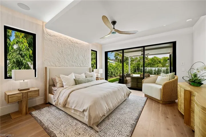 Bedroom featuring access to exterior, light wood-style floors, and a ceiling fan