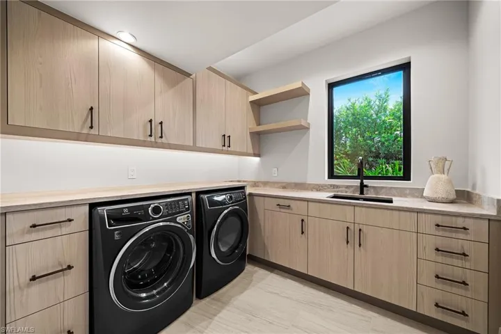 Washroom featuring cabinet space and washing machine and clothes dryer