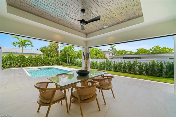 View of pool featuring a patio area, outdoor dining area, and ceiling fan