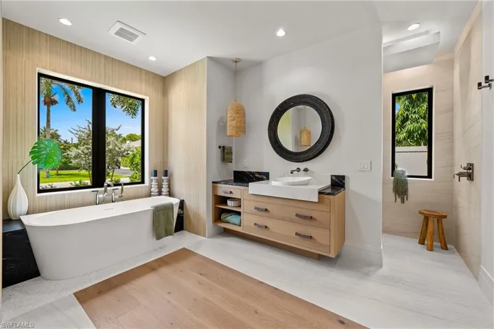 Full bathroom with a freestanding tub, vanity, recessed lighting, and wood finished floors