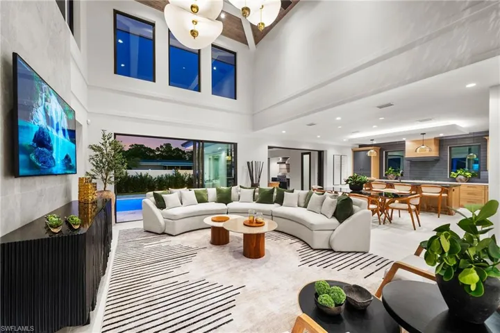 Living area featuring a towering ceiling and recessed lighting