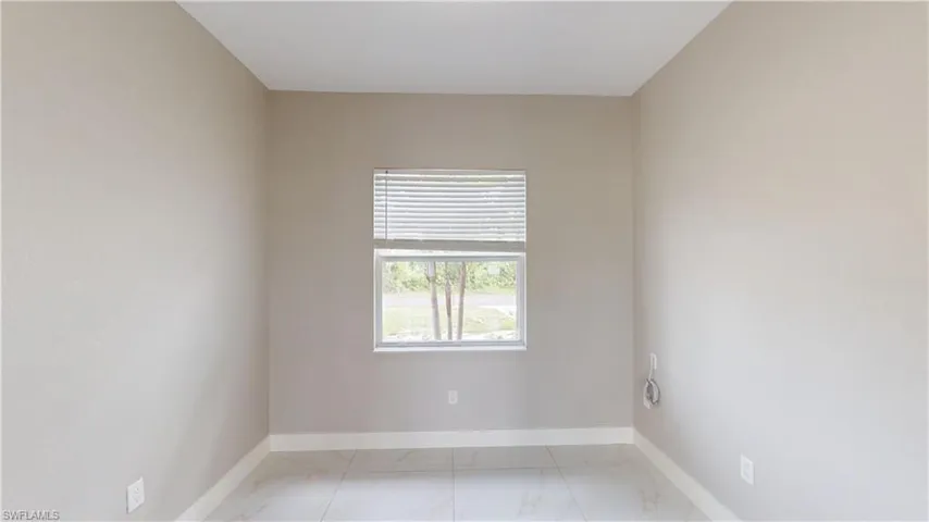 Spare room with light marble finish floors and baseboards
