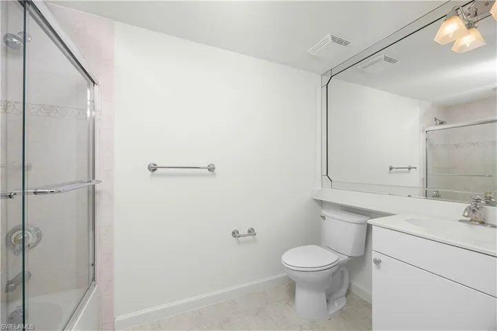 Full bath featuring vanity, tiled shower / bath combo, and light tile patterned floors