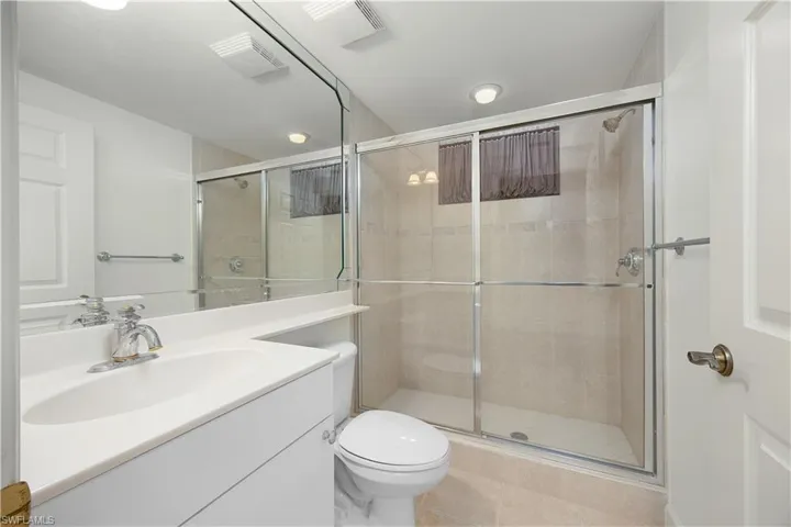 Full bathroom featuring a stall shower, vanity, and light tile patterned flooring