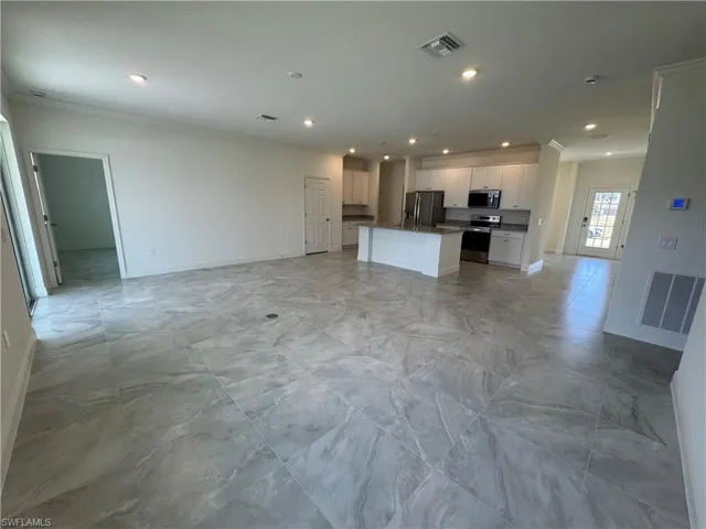 Unfurnished living room featuring baseboards, recessed lighting, and crown molding