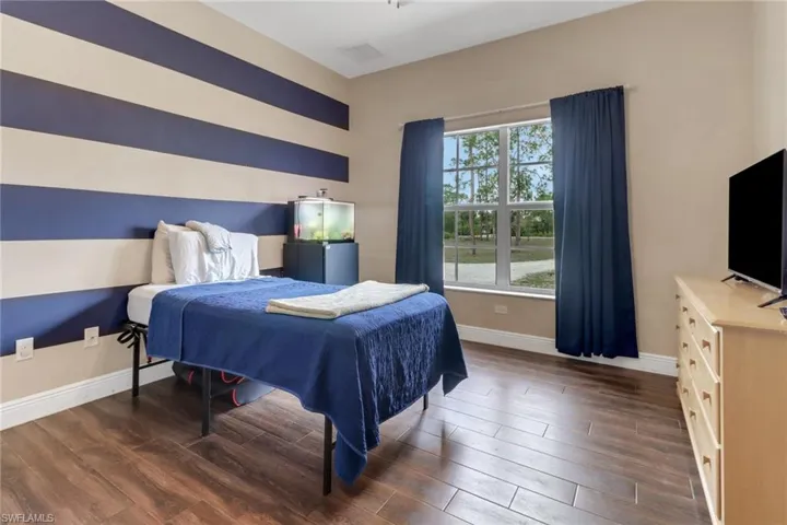 Bedroom featuring wood finished floors, visible vents, and baseboards