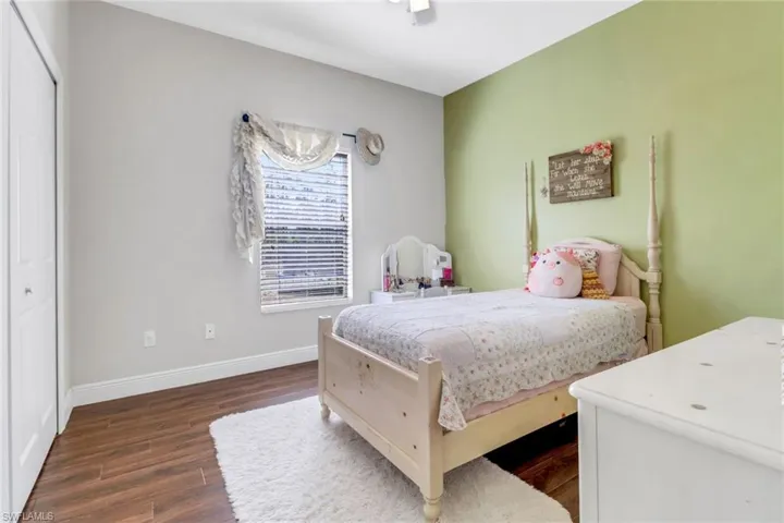 Bedroom with baseboards and dark wood-type flooring