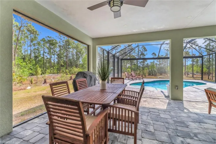 Sunroom featuring outdoor dining space, a swimming pool, and ceiling fan