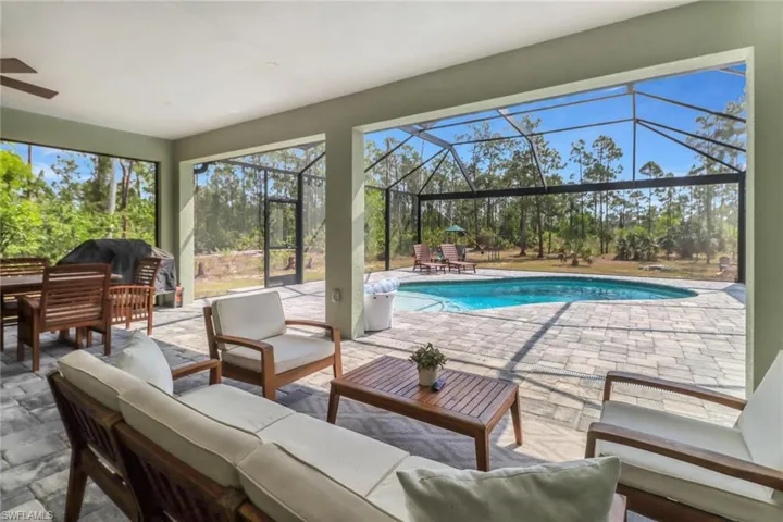 Pool with grilling area, a lanai, a patio, and an outdoor hangout area