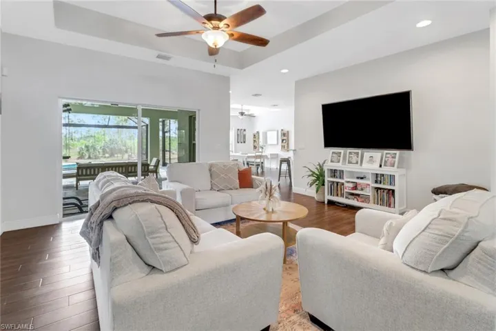 Living area featuring recessed lighting, wood finished floors, visible vents, a ceiling fan, and baseboards
