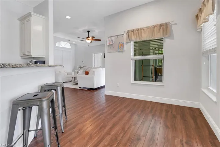 Living room with recessed lighting, a ceiling fan, baseboards, and dark wood-style flooring