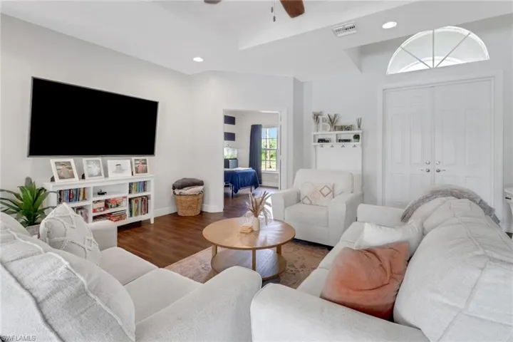 Living area with ceiling fan, wood finished floors, visible vents, and recessed lighting
