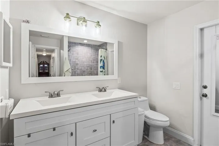 Second bathroom with dual sinks, bathtub and access to the pool/lanai.
