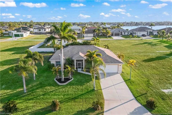 Stunning aerial shot highlighting the home’s spacious lot, surrounding greenery, and peaceful NW Cape Coral neighborhood.