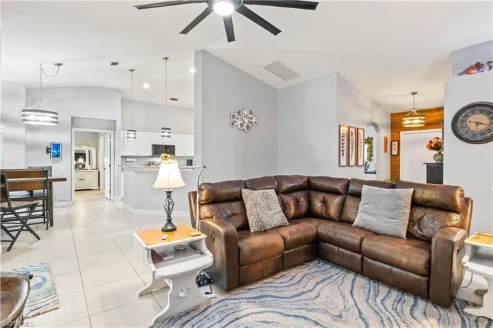 Bright and open living area featuring high ceilings, abundant natural light, and a seamless flow into the kitchen.