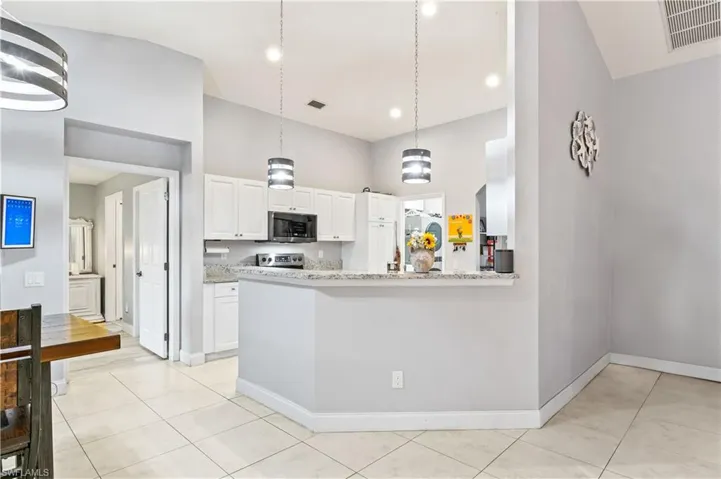 Beautifully designed kitchen with a breakfast bar and easy access to the lanai and pool area, ideal for entertaining.