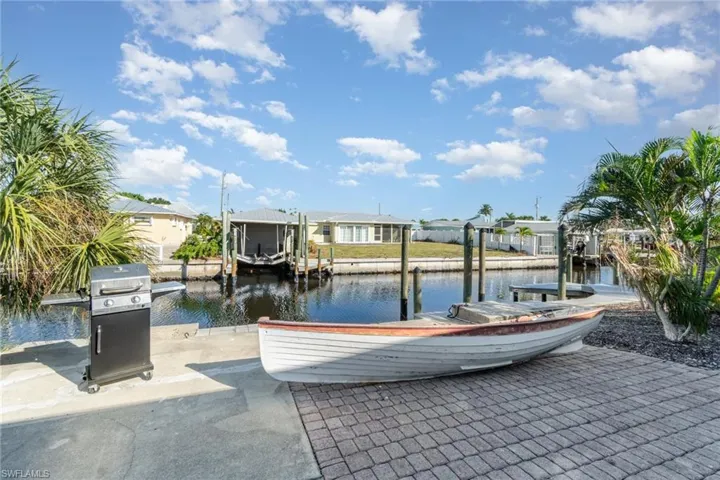 Dock with a water view, boat lift, and a residential view