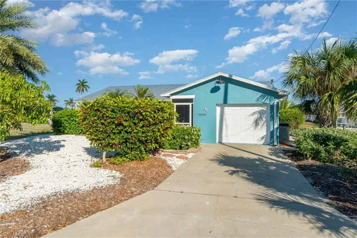 View of front of property featuring a garage, stucco siding, and driveway