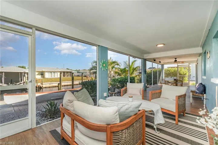 Sunroom / solarium with an outdoor hangout area, a water view, and a ceiling fan