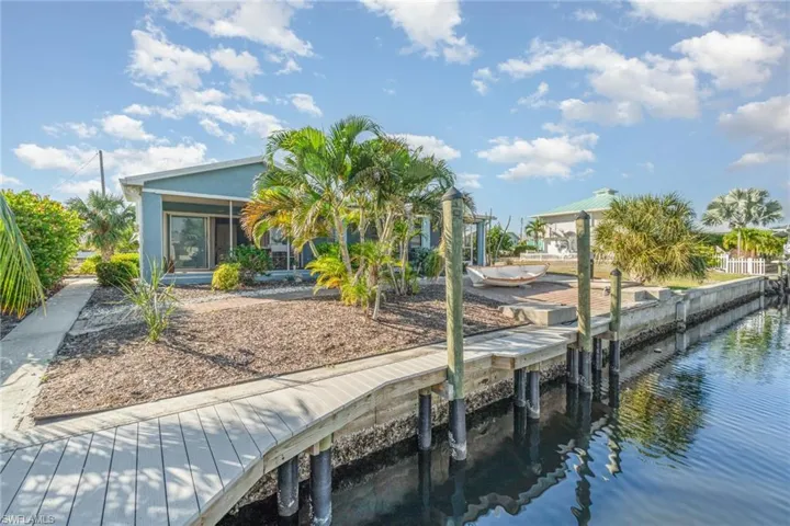 Dock featuring a sunroom, a water view, and boat lift