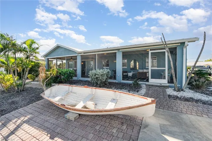 Back of property featuring a sunroom, a patio area, and a ceiling fan