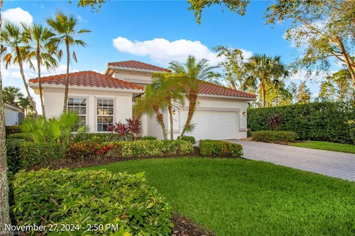 Mediterranean / spanish house with a front yard and a garage