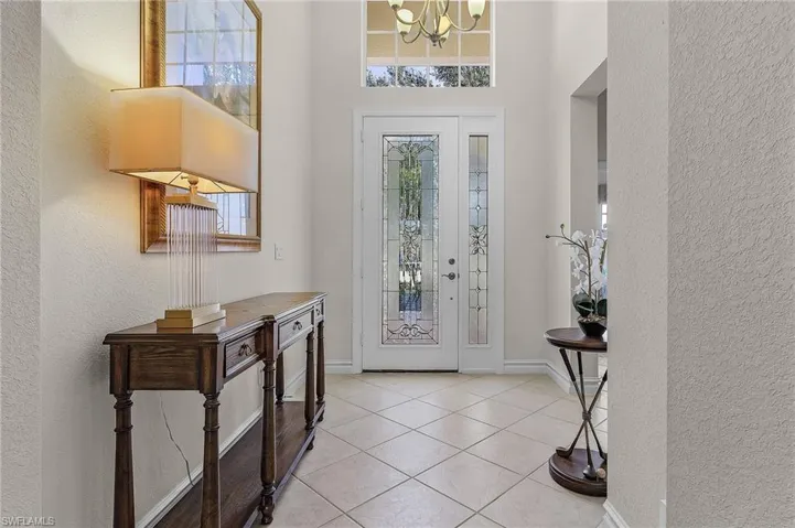 Tiled entryway with a chandelier and a wealth of natural light