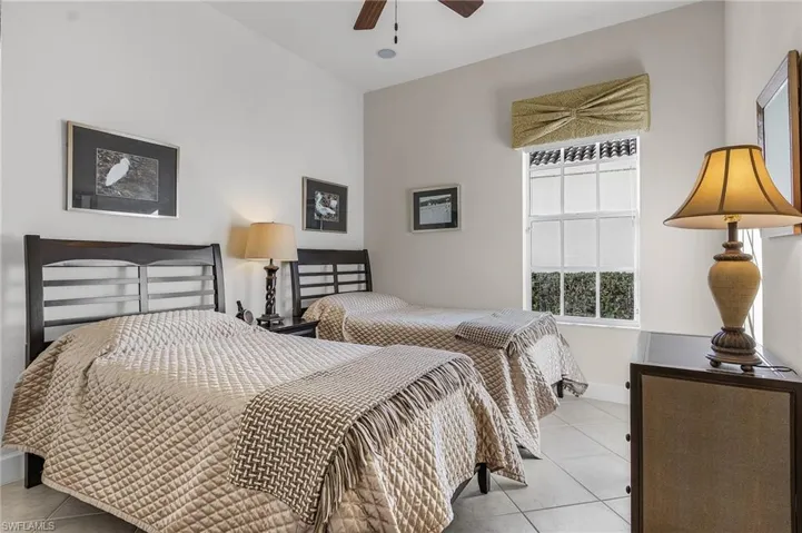 Bedroom with ceiling fan and light tile patterned floors