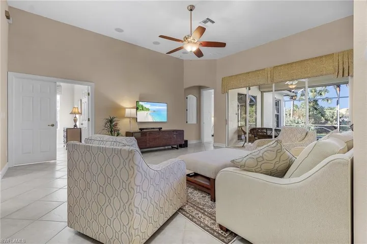 Living room with light tile patterned floors and ceiling fan