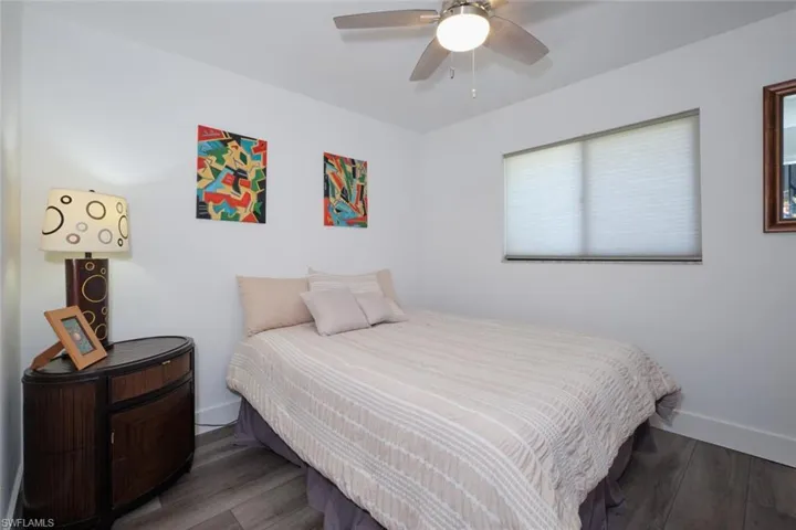 Bedroom with ceiling fan and dark wood-type flooring