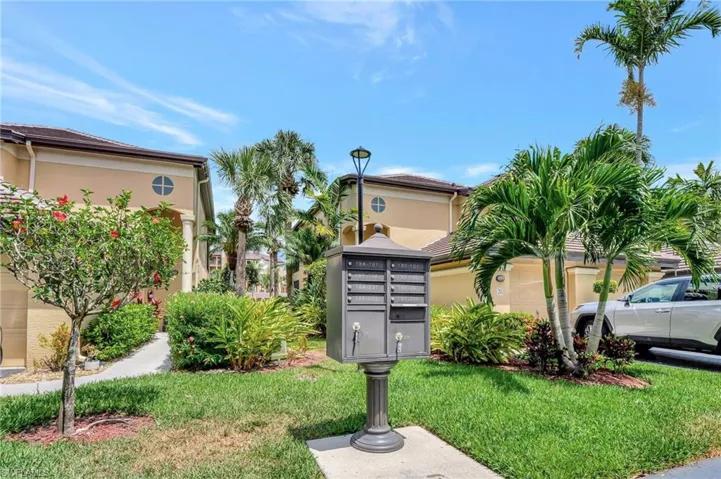 View of property's community featuring a lawn and mail area
