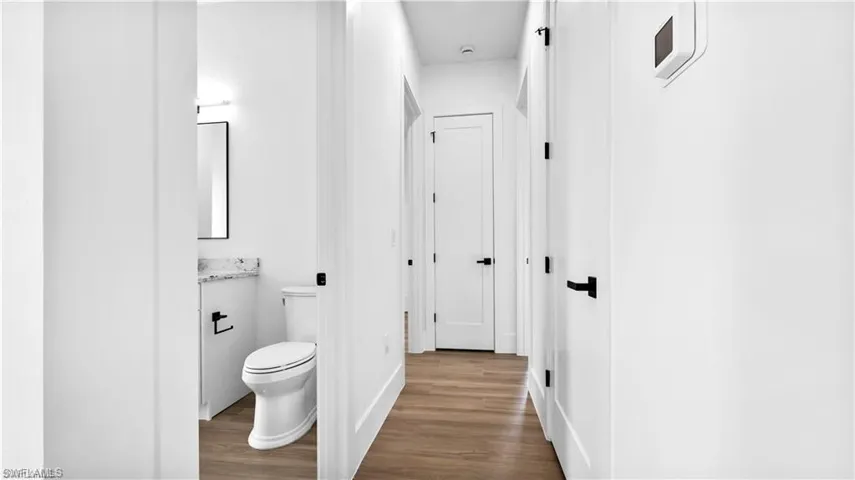 Bathroom with vanity, toilet, and wood-type flooring