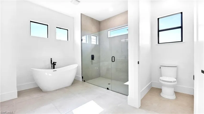 Bathroom with tile patterned floors, toilet, and independent shower and bath